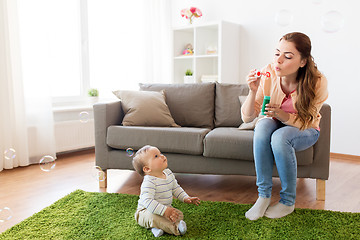 Image showing mother with soap bubbles playing with baby at home