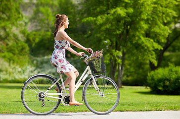 Image showing happy woman riding fixie bicycle in summer park