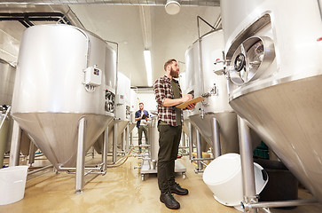 Image showing men with clipboard at craft brewery or beer plant