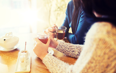 Image showing close up of couple drinking tea at cafe