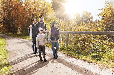 Image showing happy family with backpacks hiking in woods