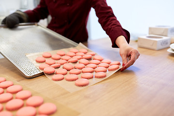 Image showing chef with macarons on oven tray at confectionery