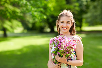 Image showing happy young woman with flowers in summer park