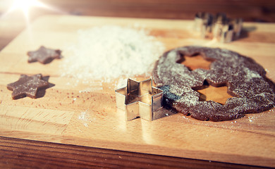 Image showing close up of ginger dough, molds and flour on board