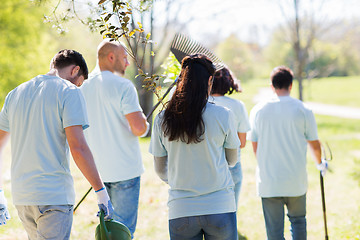 Image showing happy volunteers with seedlings and garden tools