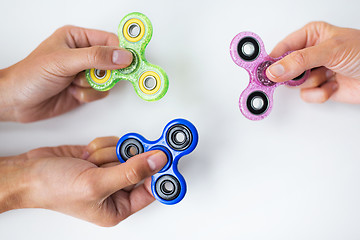 Image showing close up of hands playing with fidget spinners