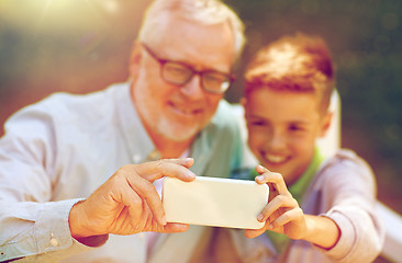 Image showing old man and boy taking selfie by smartphone