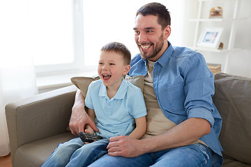 Image showing father and son with remote watching tv at home