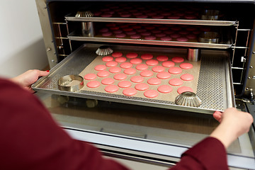 Image showing chef with macarons on oven tray at confectionery