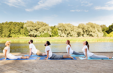 Image showing group of people making yoga exercises outdoors