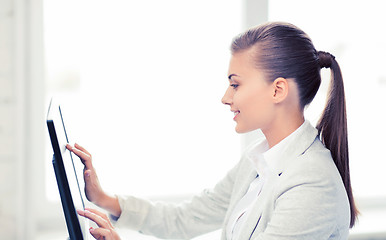 Image showing smiling businesswoman with touchscreen in office