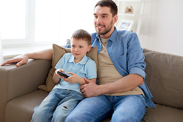 Image showing father and son with remote watching tv at home