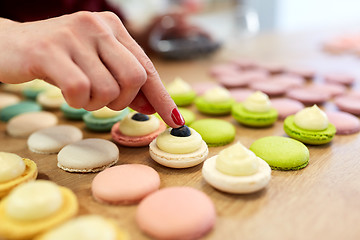 Image showing chef decorating macarons shells at pastry shop