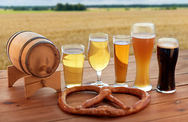 Image showing beer glasses, barrel and pretzel over cereal field