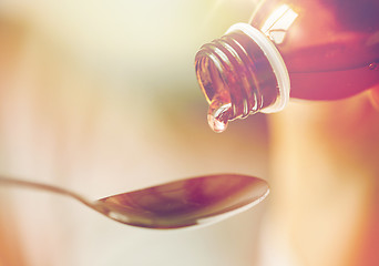 Image showing medication or antipyretic syrup and spoon