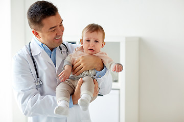 Image showing happy doctor or pediatrician with baby at clinic