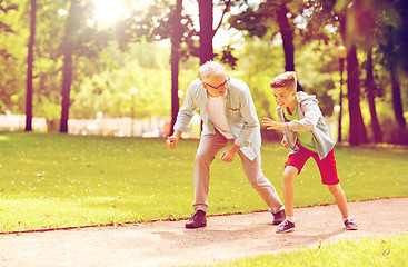 Image showing grandfather and grandson racing at summer park