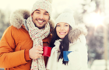 Image showing happy couple with tea cups over winter landscape