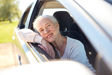 Image showing happy senior woman driving in car with open window