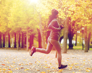 Image showing close up of young woman running in autumn park