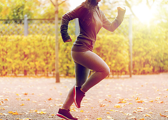 Image showing close up of young woman running in autumn park