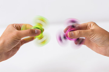 Image showing close up of hands playing with fidget spinners