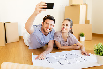 Image showing couple with boxes and blueprint moving to new home