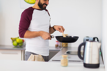 Image showing man with frying pan cooking food at home kitchen