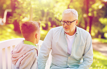 Image showing grandfather and grandson talking at summer park