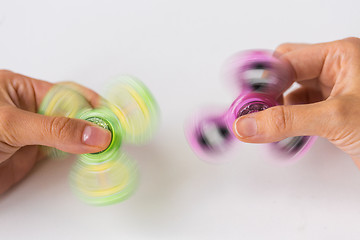 Image showing close up of hands playing with fidget spinners