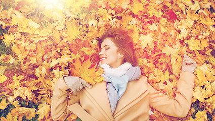 Image showing beautiful happy woman lying on autumn leaves