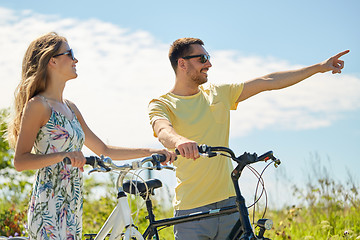 Image showing happy young couple with bicycles outdoors