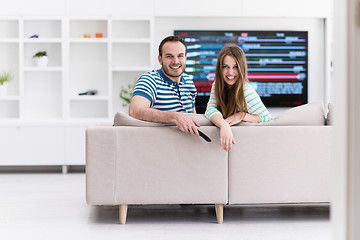 Image showing Young couple on the sofa watching television