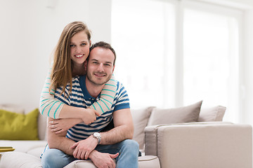 Image showing young handsome couple hugging on the sofa