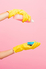 Image showing The woman\'s hand cleaning on a pink background. Cleaning or housekeeping concept