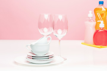 Image showing Several plates, a kitchen sponges and a plastic bottles with natural dishwashing liquid soap in use for hand dishwashing.