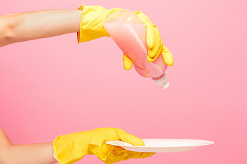 Image showing Hands in yellow protective gloves washing a plate