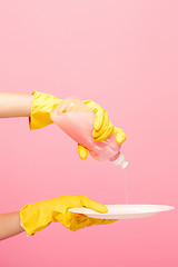 Image showing Hands in yellow protective gloves washing a plate