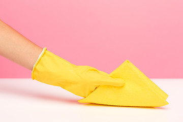 Image showing The woman\'s hand cleaning on a pink background. Cleaning or housekeeping concept