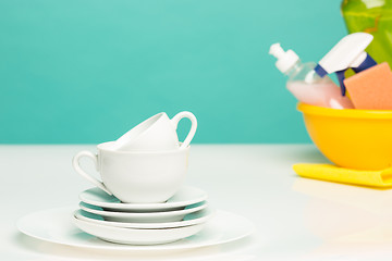 Image showing Several plates, a kitchen sponges and a plastic bottles with natural dishwashing liquid soap in use for hand dishwashing.