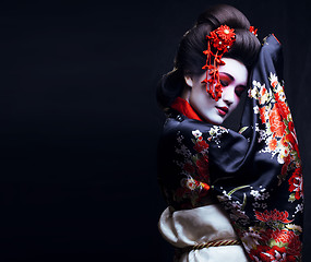 Image showing young pretty geisha in kimono with sakura and decoration