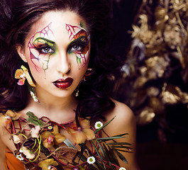 Image showing beauty woman with face art and jewelry from flowers orchids close up