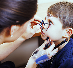 Image showing little cute child making facepaint on birthday party, zombie Apo