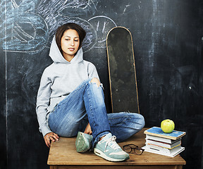 Image showing young teenage girl sitting in classroom at blackboard on table, lifestyle education people concept