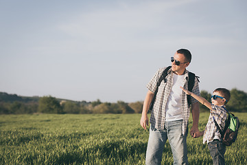 Image showing Father and son playing on the field at the day time.