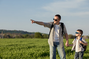 Image showing Father and son playing on the field at the day time.