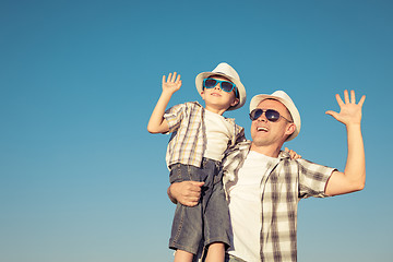 Image showing Father and son playing on the field at the day time.