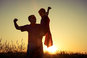 Image showing Father and son playing superhero at the sunset time.