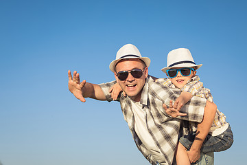 Image showing Father and son playing on the field at the day time.