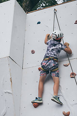 Image showing little boy climbing a rock wall outdoor.